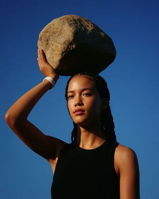 a woman holding a rock on her head