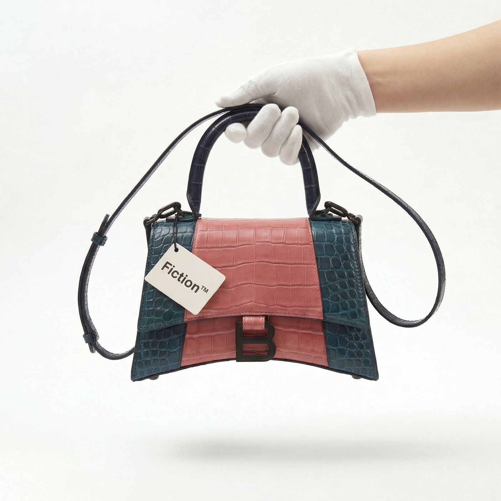 a hand holding a small purse with a tag on it