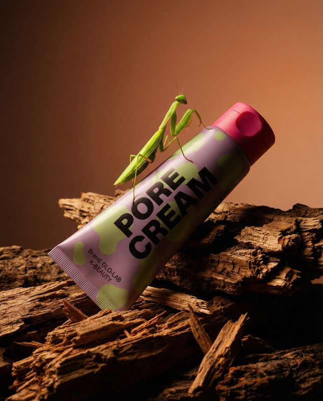 a green insect sitting on top of a tube of cream