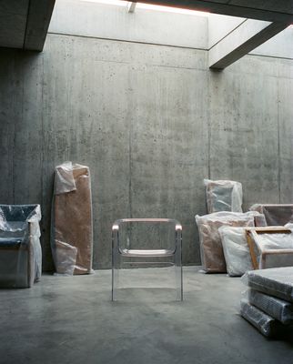 a chair sitting in a room next to a pile of mattresses