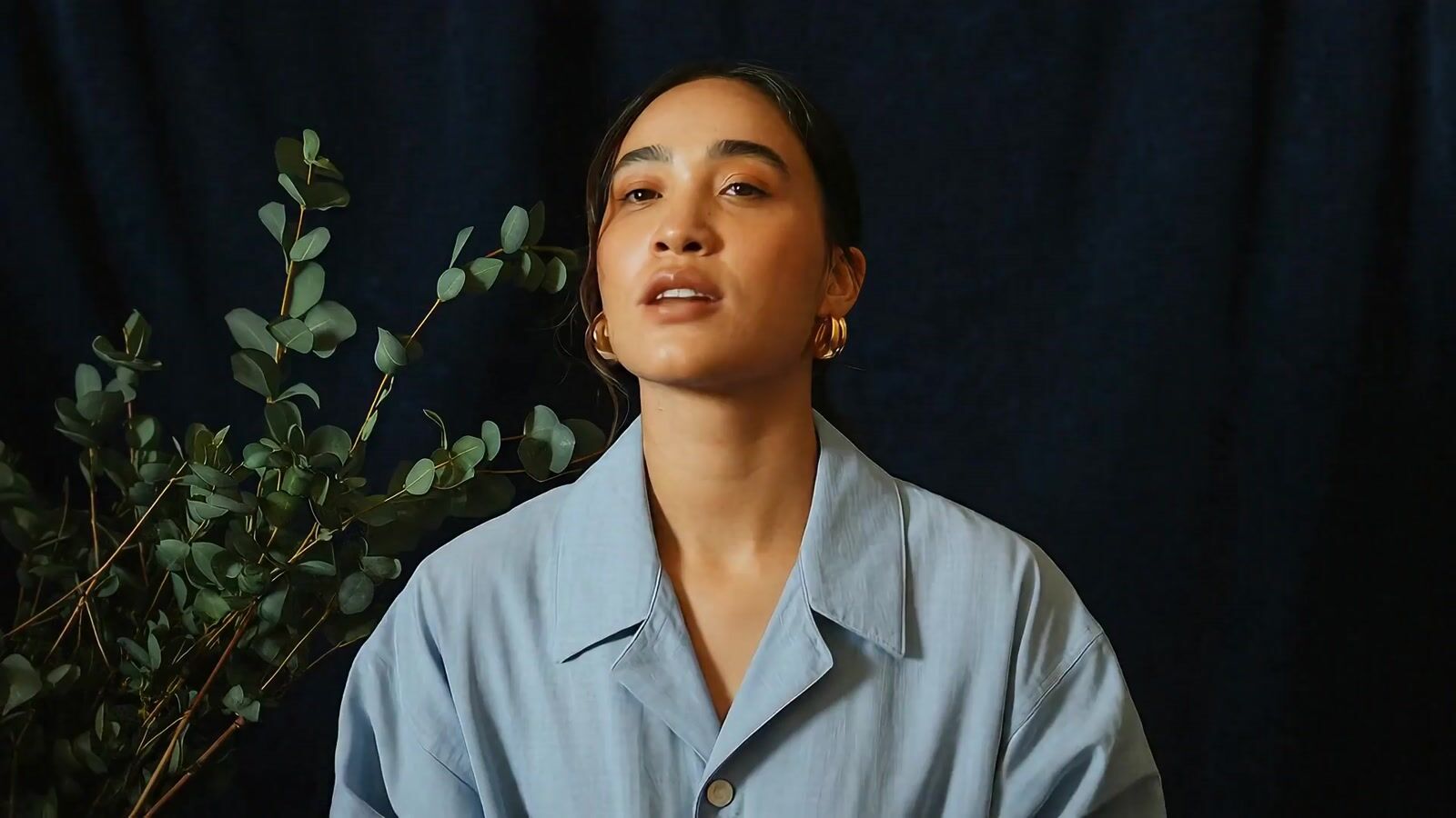 a woman standing in front of a plant