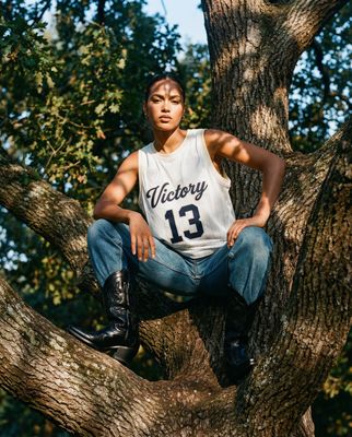 a young man sitting on a tree branch