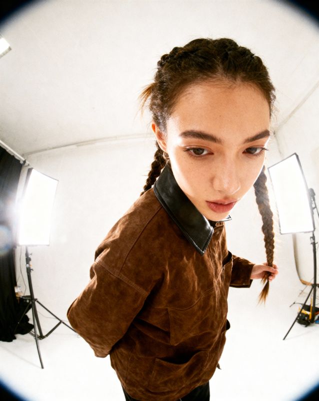 a woman with braids standing in front of a camera