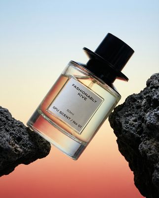 a bottle of perfume sitting on top of a rock
