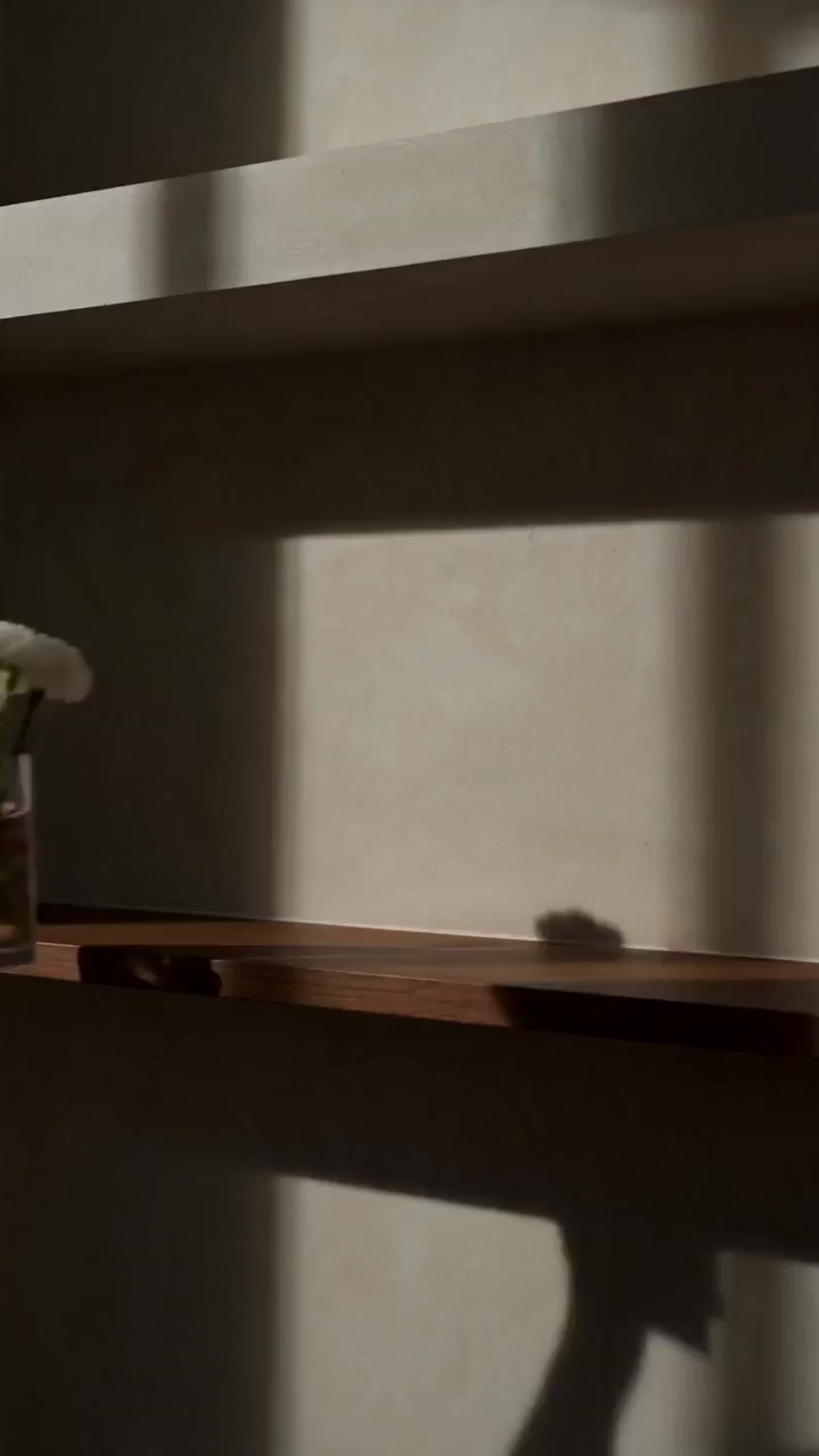 the shadow of a person's hand on a shelf