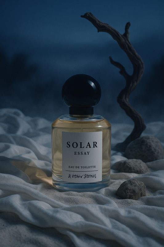 a bottle of perfume sitting on top of a bed of sand