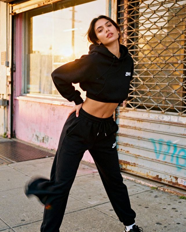 a woman in a crop top and sweat pants posing for a picture