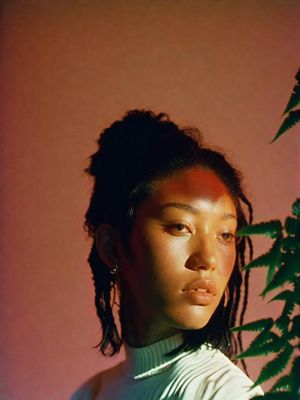 a woman standing in front of a potted plant