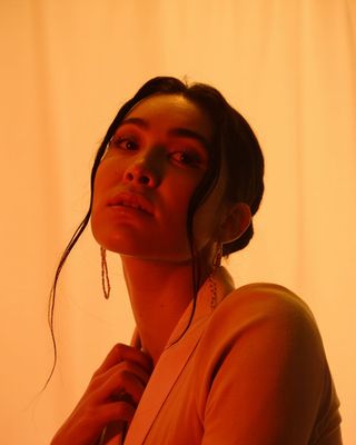 a woman wearing ear rings and a sweater