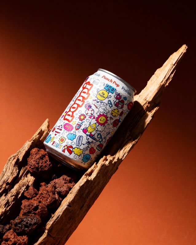 a can of soda sitting on top of a piece of wood