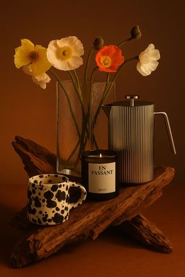 a vase with flowers and a candle on a table