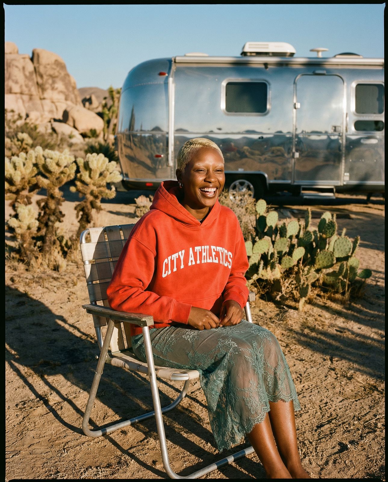 a woman sitting in a chair in front of a camper