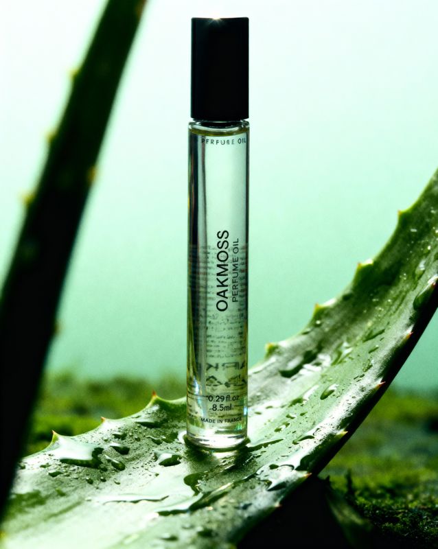 a bottle of perfume sitting on top of a leaf