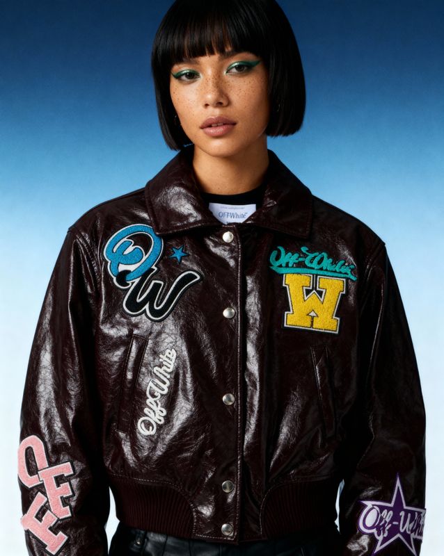 a woman wearing a leather jacket with patches on it