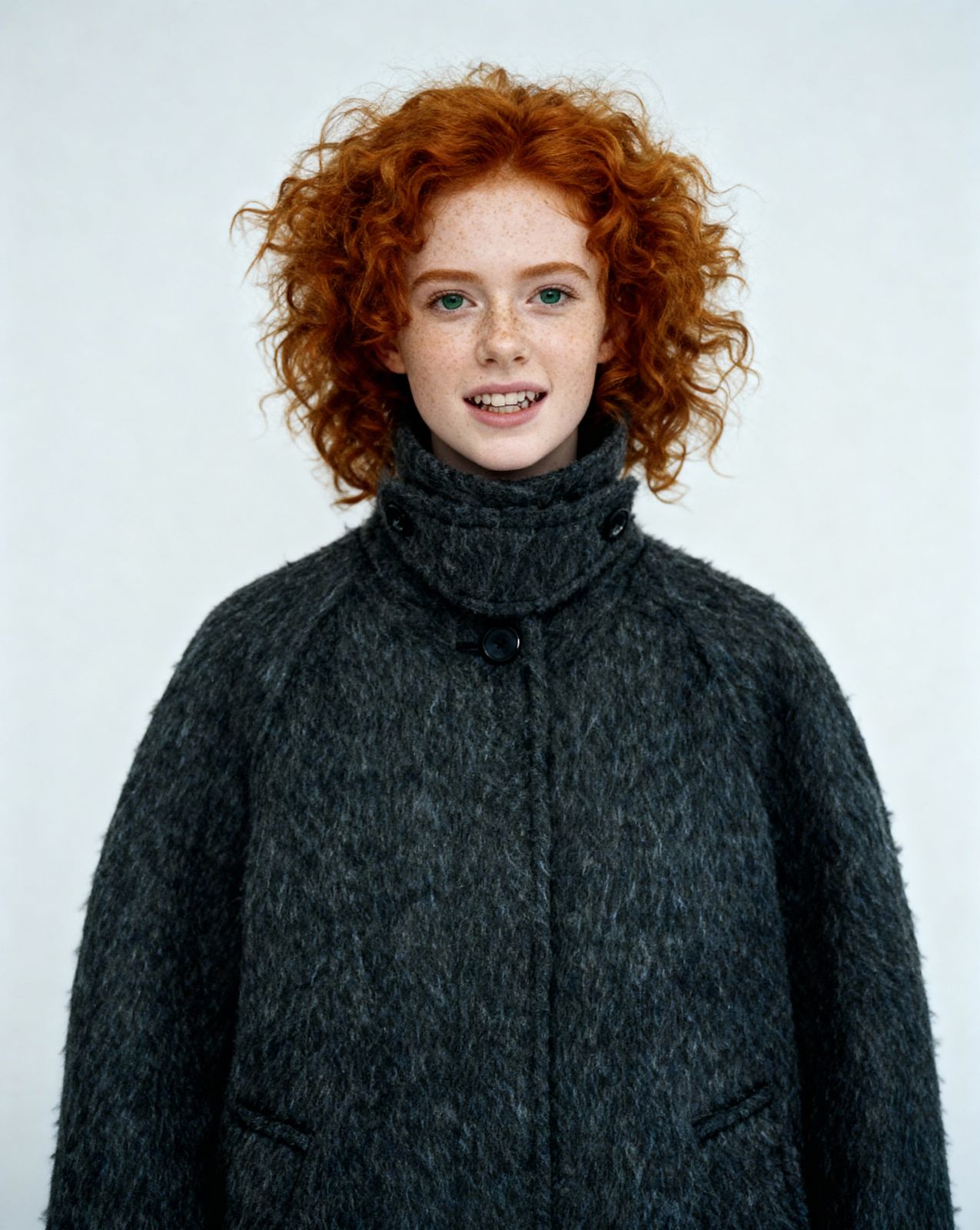 a woman with red hair wearing a black coat