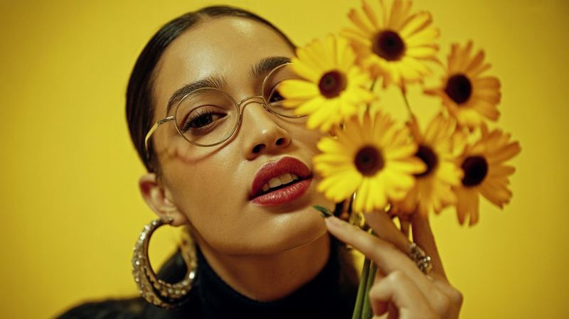a woman holding a bunch of yellow flowers