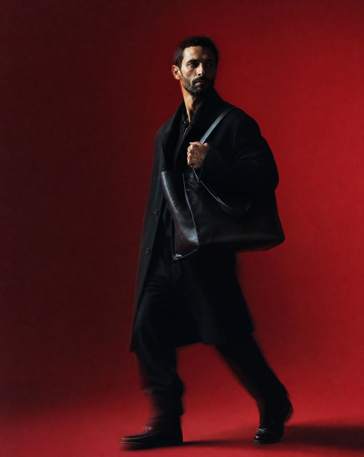 a man in a black coat and black pants