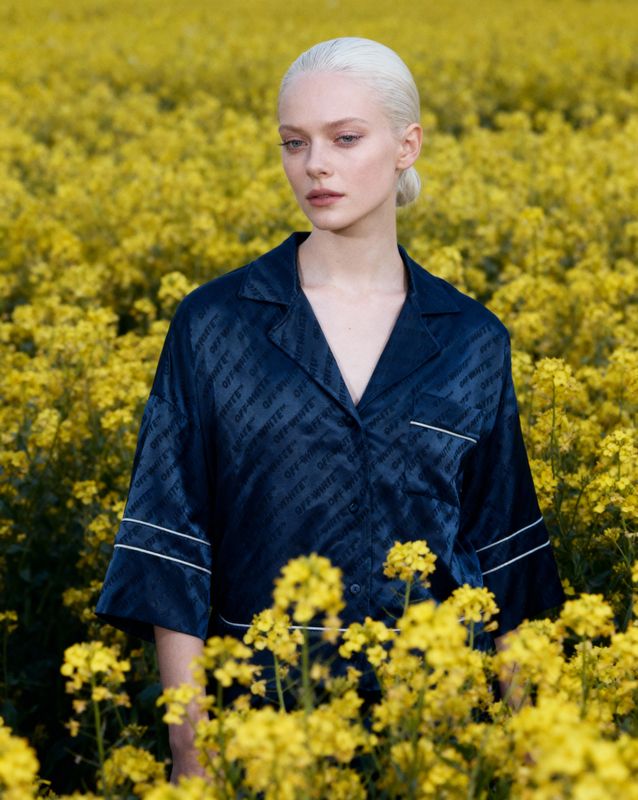 a woman standing in a field of yellow flowers