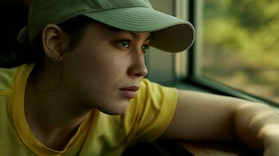 a woman wearing a hat looking out a window