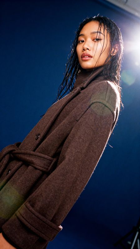 a woman with dreadlocks standing in front of a camera