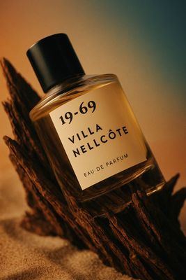 a bottle of perfume sitting on top of a piece of wood