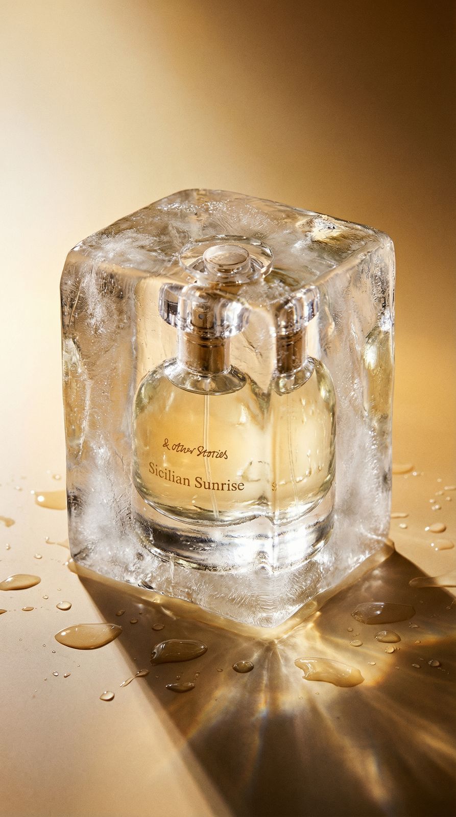 a bottle of perfume sitting on top of an ice block