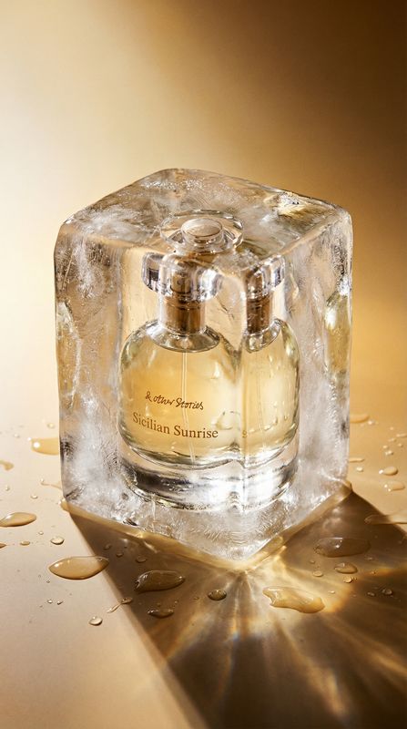 a bottle of perfume sitting on top of an ice block