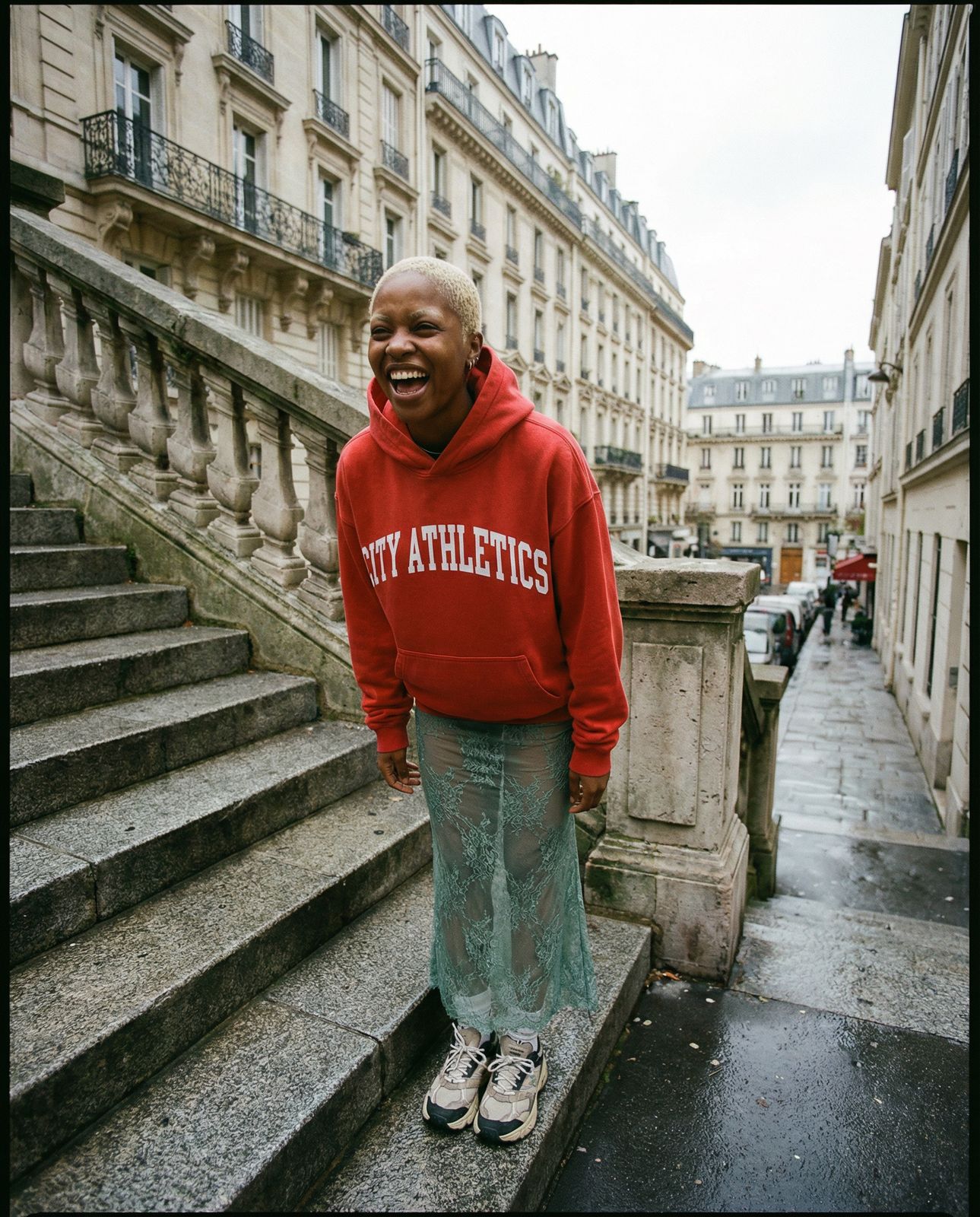 a man in a red sweatshirt standing on some steps