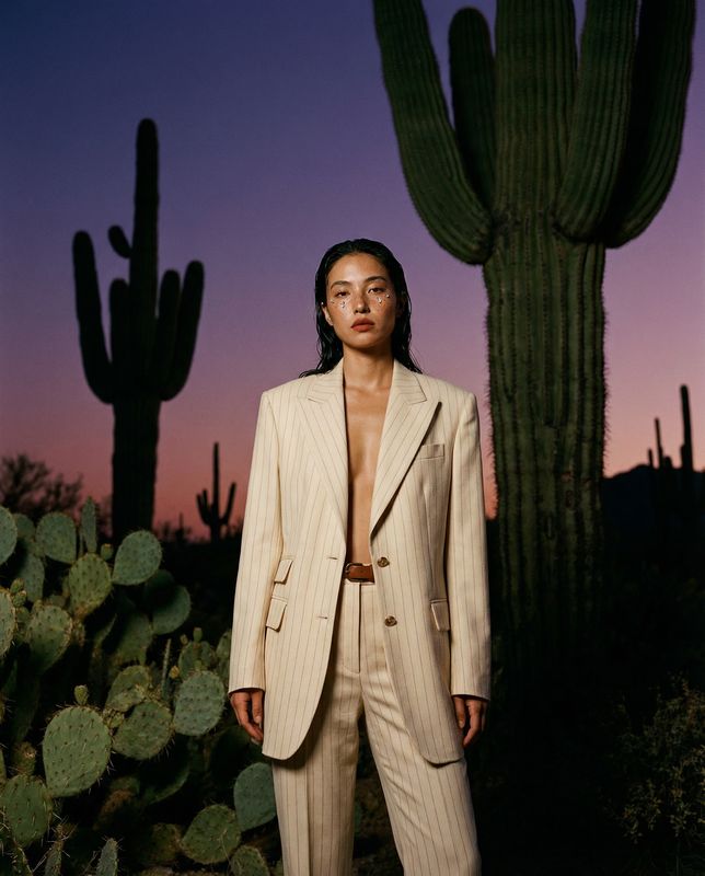 a woman standing in front of a cactus
