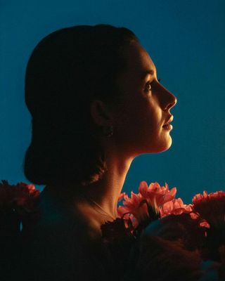 a woman with flowers in her hair looking off into the distance