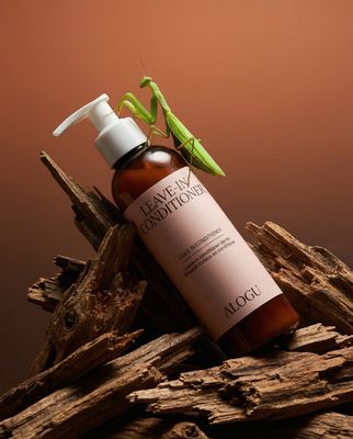 a bottle of liquid sitting on top of a pile of wood