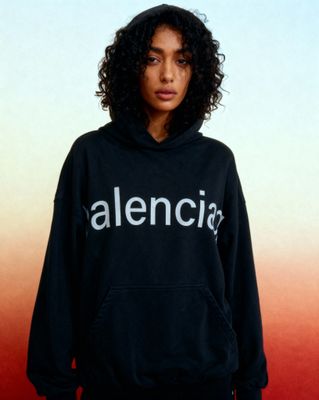 a woman wearing a black sweatshirt with the word alencia printed on it