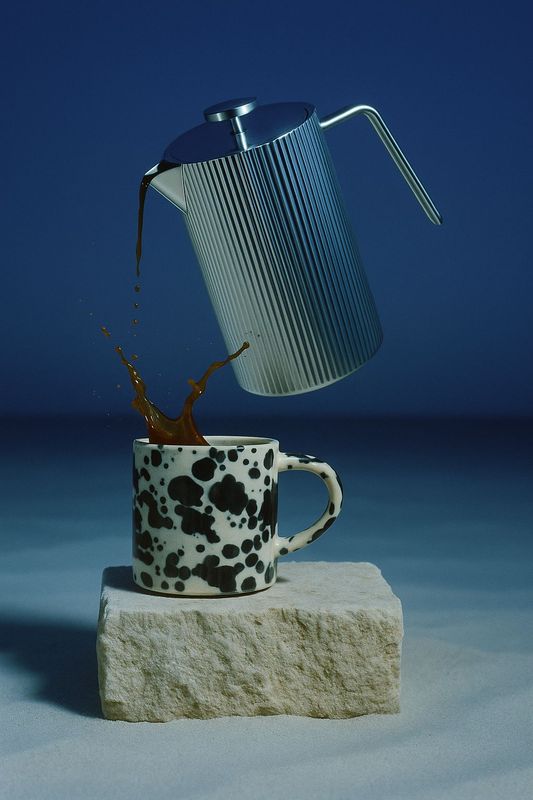 a teapot pouring tea into a cup on top of a rock