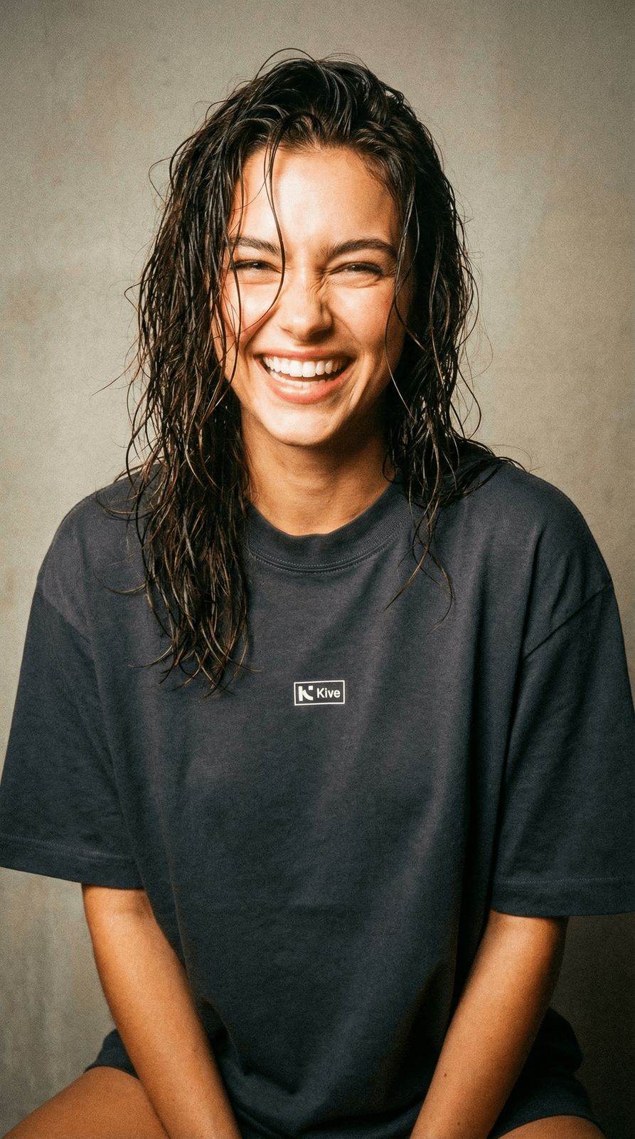 a smiling woman with wet hair sitting down