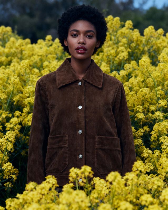 a woman standing in a field of yellow flowers