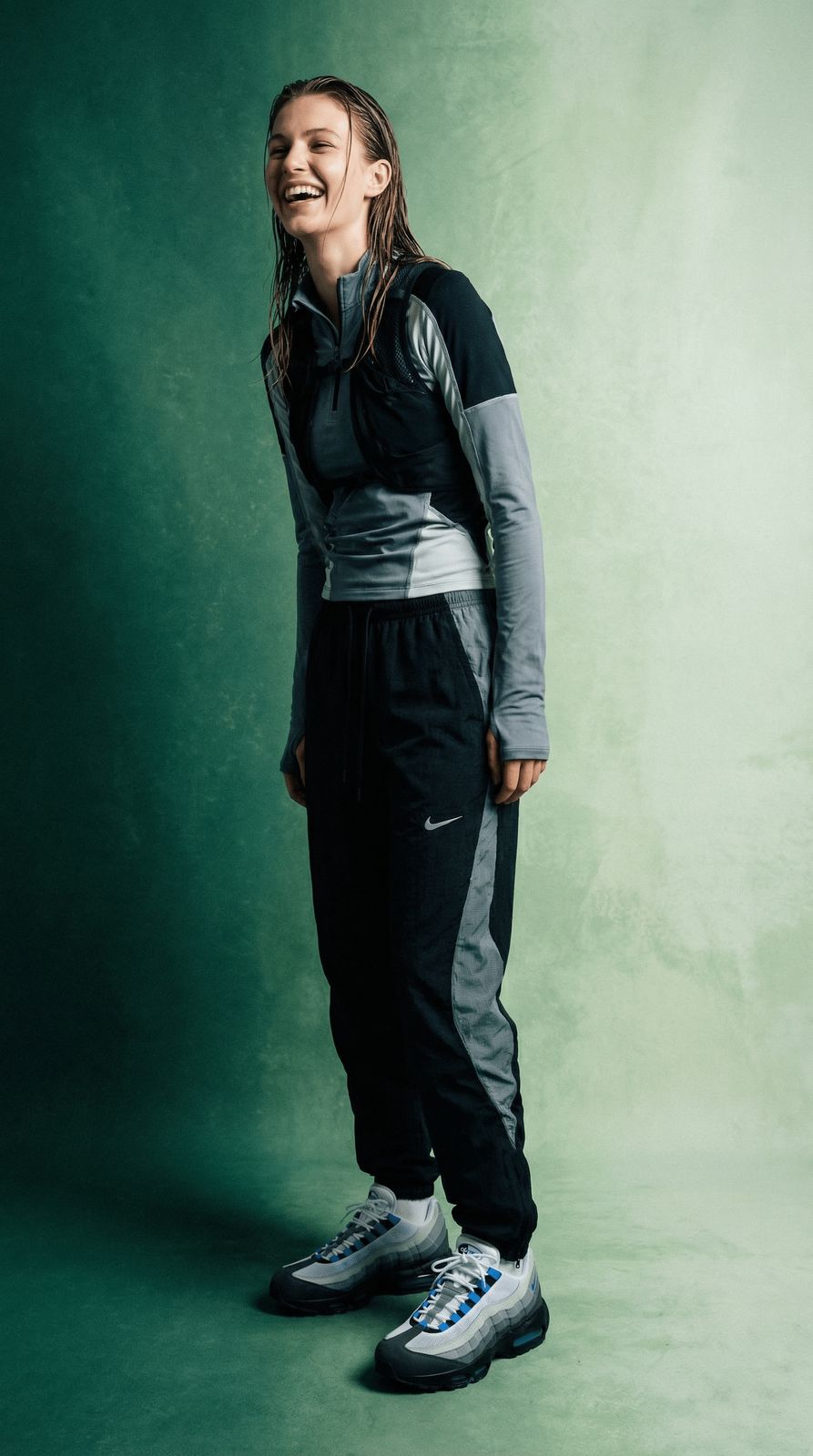 a woman standing in front of a green background