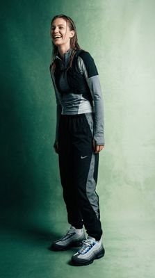 a woman standing in front of a green background