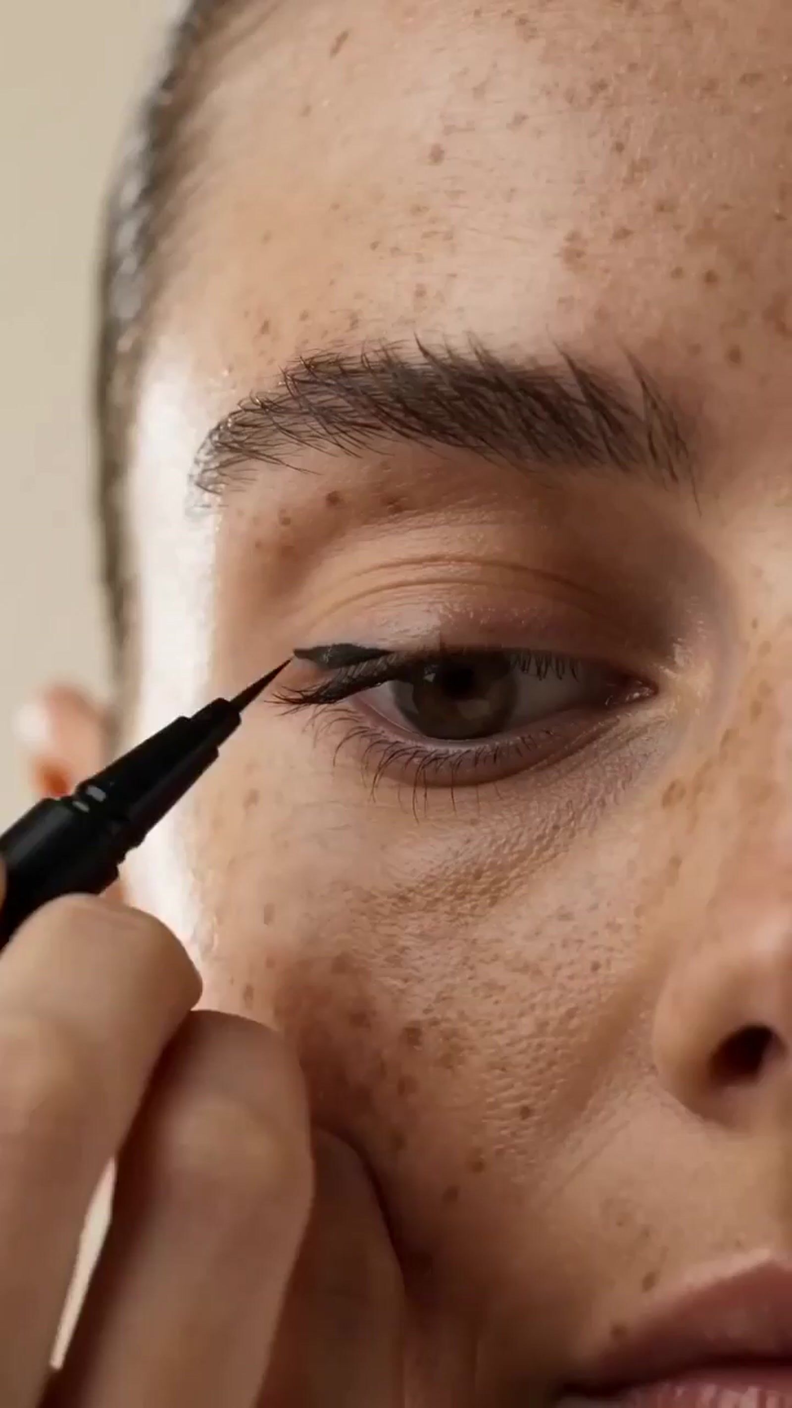 a close up of a person putting a mascara on their eye