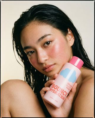 a woman holding a bottle of body lotion