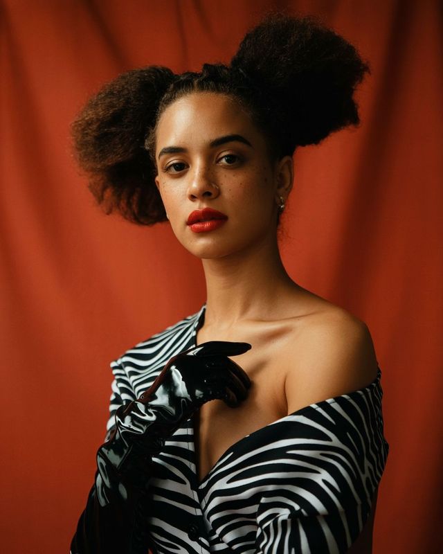 a woman in a black and white dress with a red background