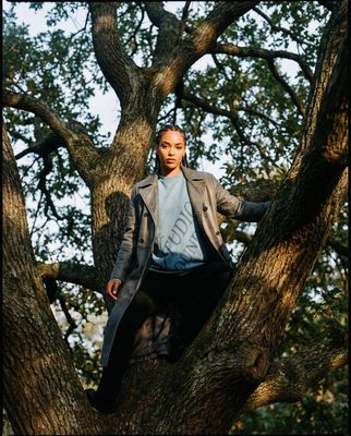 a man standing in a tree wearing a coat