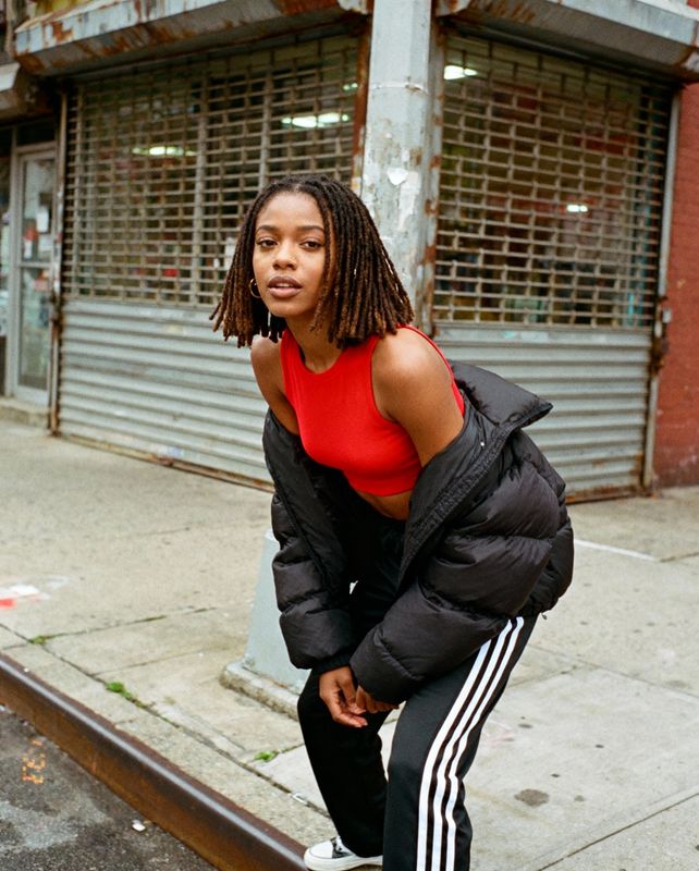 a woman in a red top is leaning on a rail
