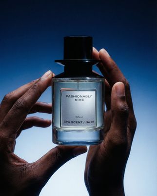 a person holding a bottle of perfume in their hands