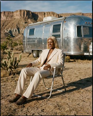 a woman sitting in a chair in front of a trailer