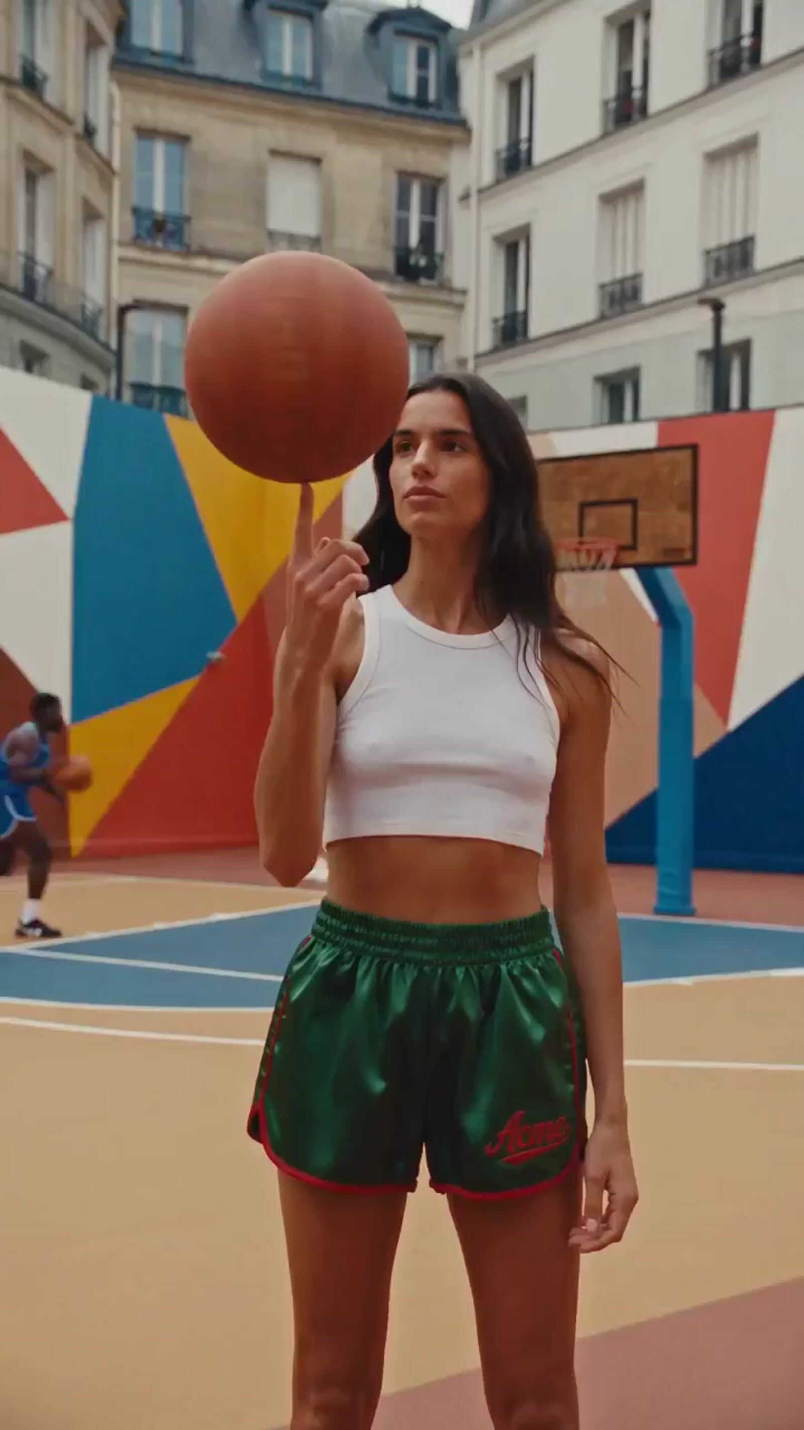 a woman standing on a basketball court holding a basketball