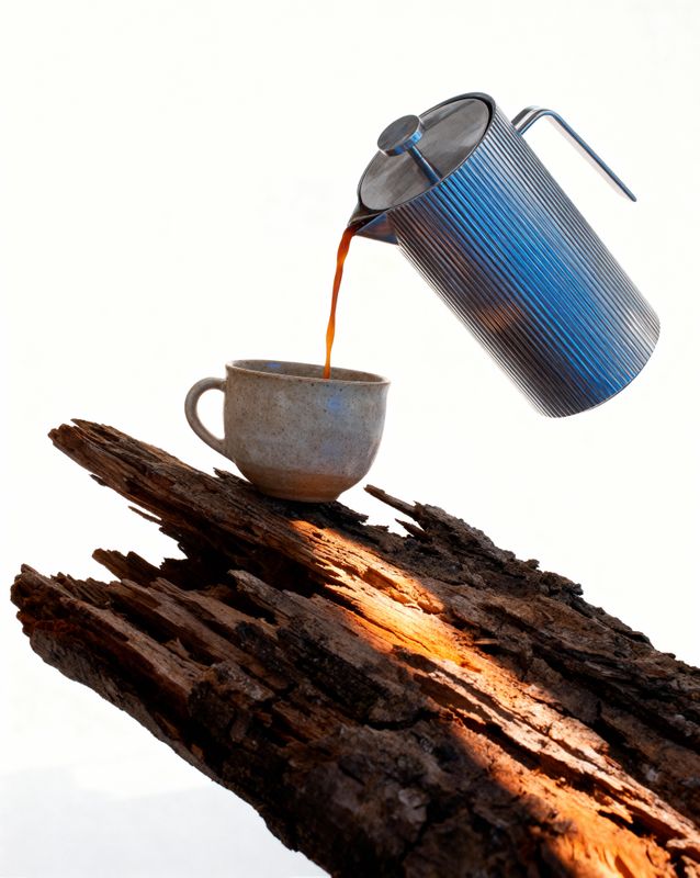 a cup of coffee being poured into a cup