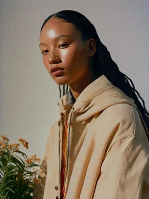 a woman with long hair wearing a beige jacket