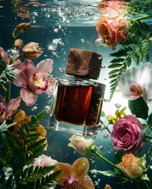 a bottle of perfume surrounded by flowers and water