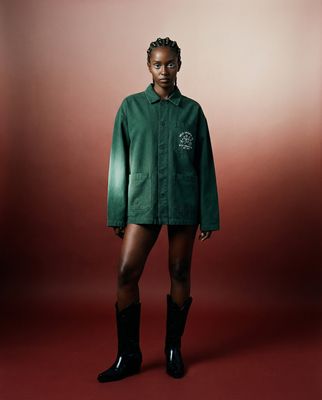 a woman in a green shirt and black boots