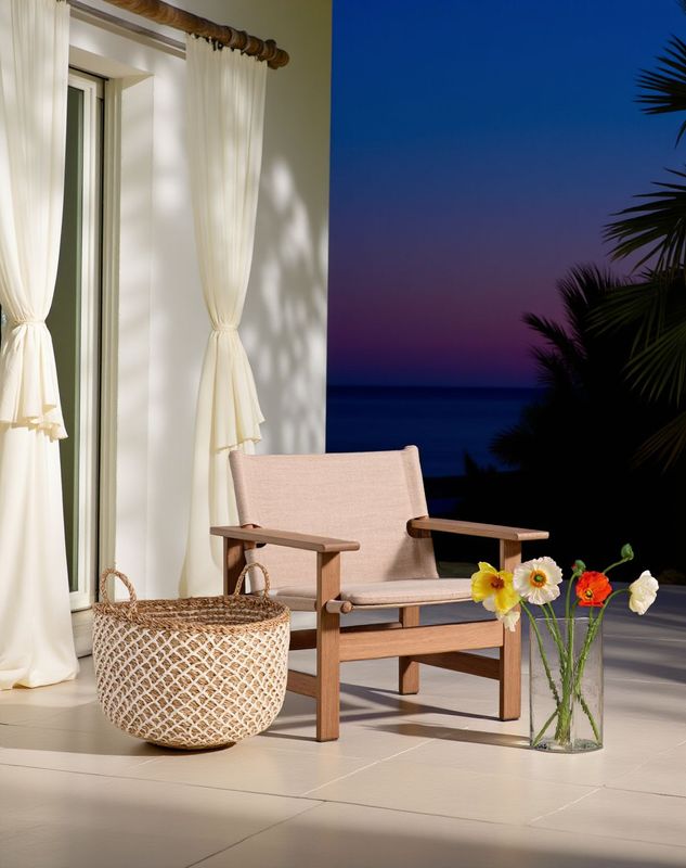 a chair sitting on a patio next to a vase of flowers